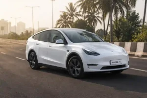 White Tesla Model Y L long-wheelbase electric SUV parked on a modern Indian highway with panoramic glass roof in morning sunlight